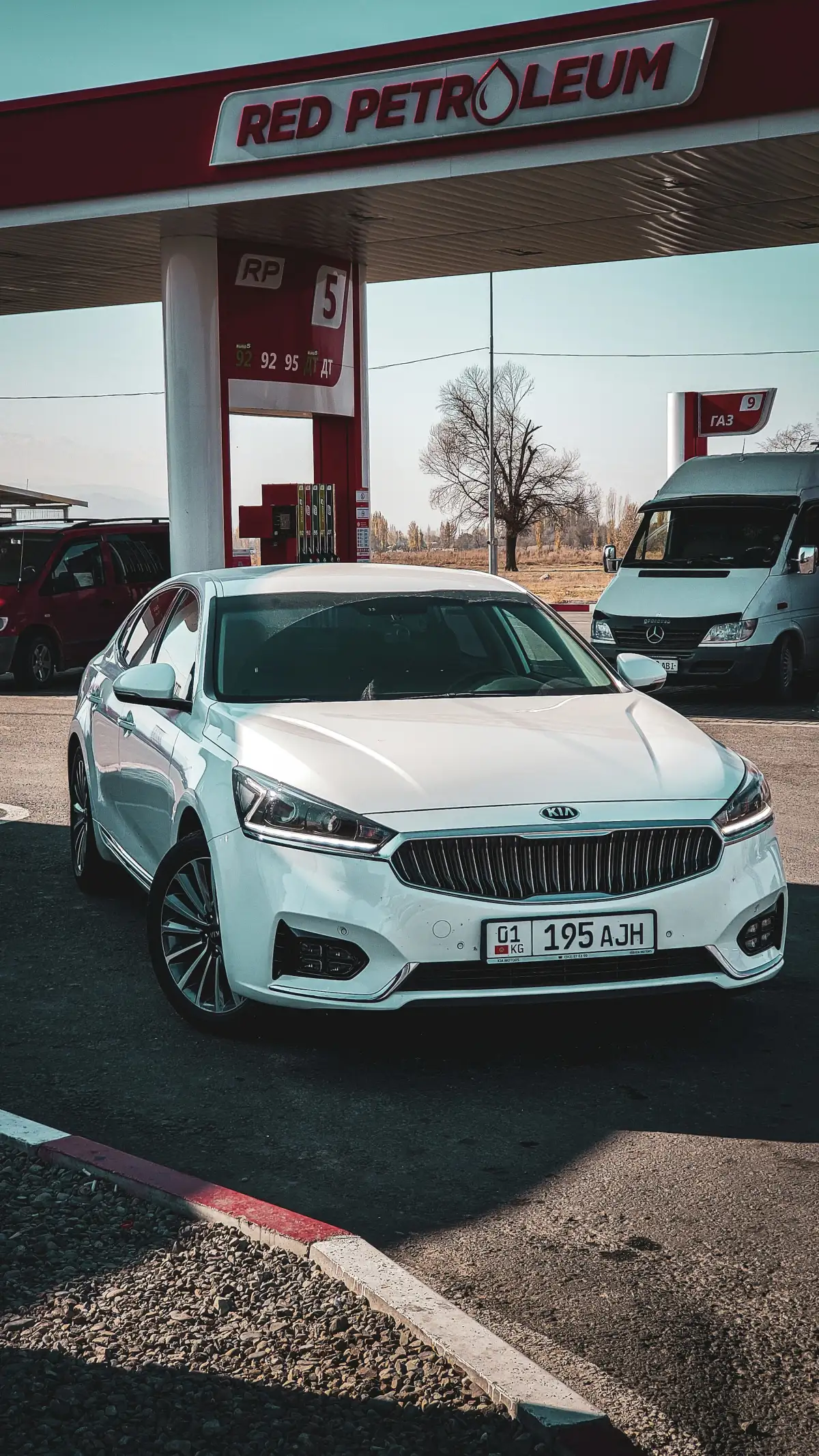 a white car parked in front of a gas station